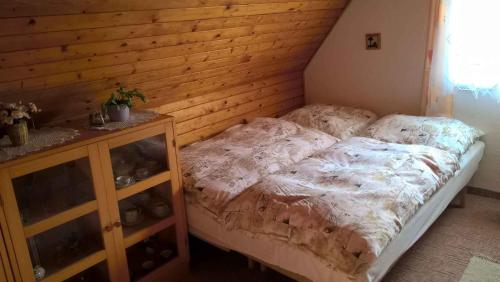 PerninkHoliday home in Pernink/Erzgebirge 1672的一间卧室设有一张床和木墙