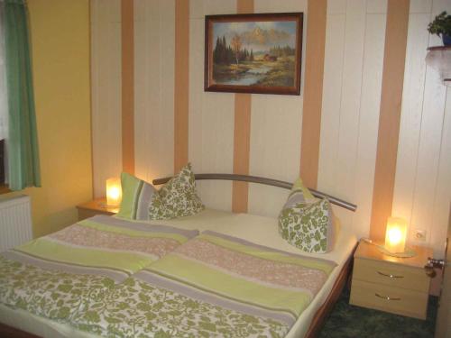 KamminkeApartment Kamminke 2的一间卧室配有一张带两盏灯和一张照片的床。