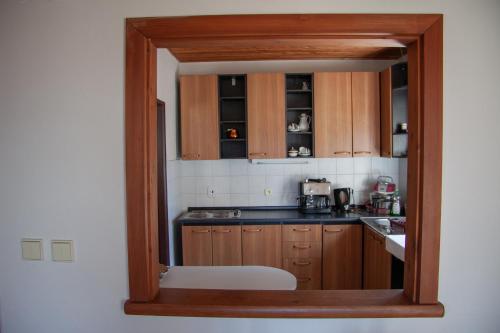 哈拉霍夫Apartment Harrachov 3的厨房配有木制橱柜和白色椅子