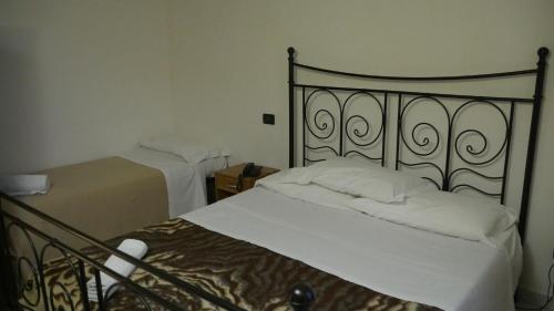 热那亚Red and Blues Music Hotel Genova的一间卧室配有两张带白色床单的床