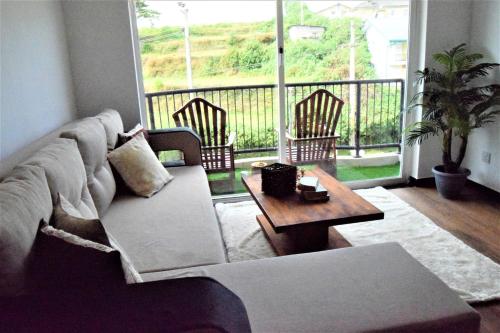 努沃勒埃利耶Lake Infinity Luxury Condos的客厅配有沙发和桌子