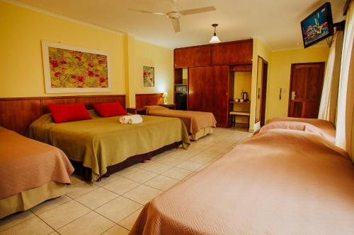 Puerto EldoradoHotel Che Roga的酒店客房 - 带两张带红色枕头的床