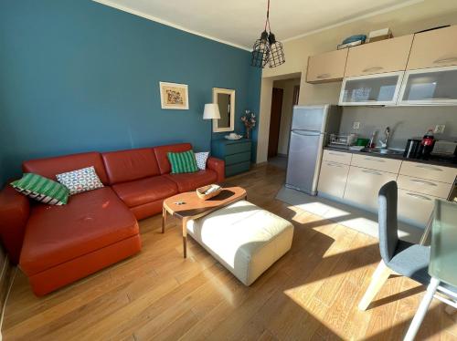 科托尔Downtown Apartment的一间带红色沙发的客厅和一间厨房