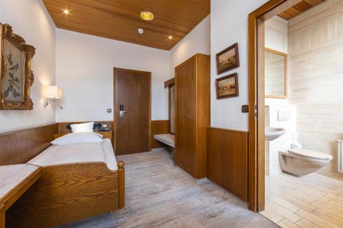 卡尔斯鲁厄AAAA库伯勒酒店的一间卧室设有一张床、一个卫生间和一个水槽