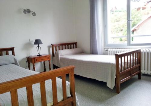 拉克河畔尚邦GÎTE GUERY的一间卧室设有两张床和窗户。