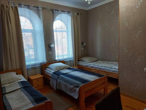 PutyvlʼГотель "Монастирський"的带2扇窗户的客房内的2张床