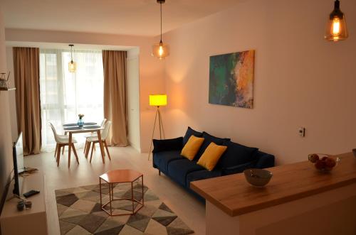 北马马亚-讷沃达里Aba's Apart Onix Blue Mamaia Nord的客厅配有蓝色的沙发和桌子