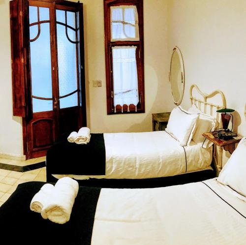 拉马约Posada Los Angelos的配有窗户的客房内的两张床