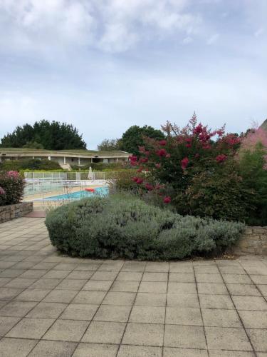 Saint-André-des-EauxAppartement Golf International de la Baule的鲜花盛开的花园和游泳池