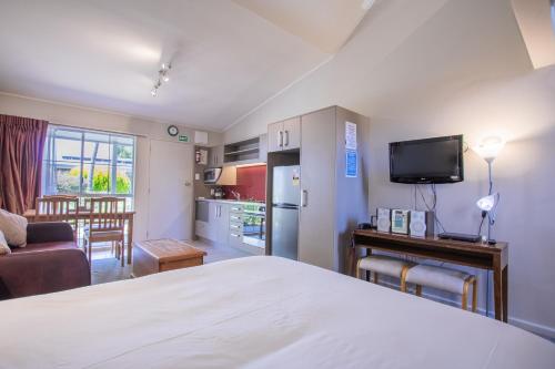 图朗伊Turangi Leisure Lodge的一间卧室配有一张床、一间厨房和一个客厅