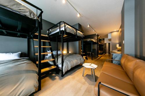 札幌VILLA KOSHIDO ODORI的客房设有两张双层床和一张沙发。