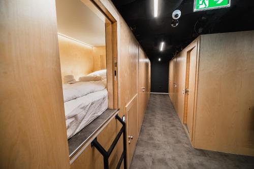 卢布尔雅那Dragons Dream Hostel的走廊上的小房间设有一张床