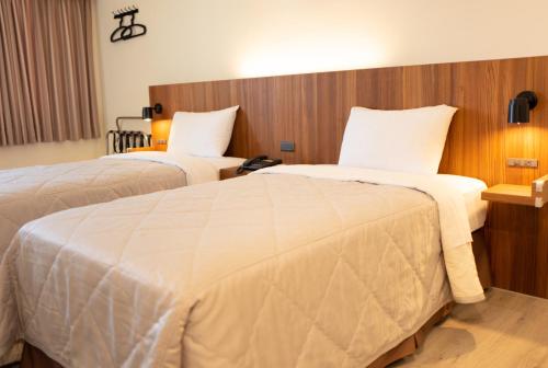 马公宝华大饭店的酒店客房,配有两张带白色床单的床