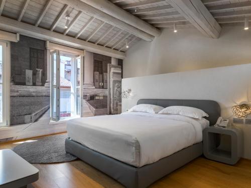 维罗纳Lords of Verona Luxury Apartments的一间卧室设有一张大床和一个大窗户