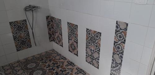 Sīdī ash ShammākhDar Mamina的浴室的墙壁上设有瓷砖和淋浴。