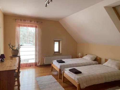 KavariPie Ezerrozēm的一间卧室设有两张床和窗户。