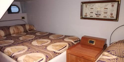 索伦托Gianetti 50' HT的一间小卧室,配有两张床和一张木桌
