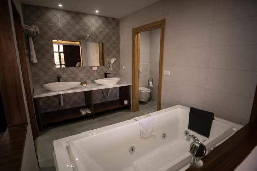 马夫罗沃拉迪卡酒店的浴室配有两个盥洗盆和浴缸。