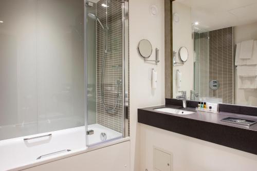 伊普斯威奇假日伊普斯威奇奥威尔酒店度假村的一间带玻璃淋浴和水槽的浴室