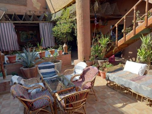 卢克索卢克索快乐之家旅舍的户外庭院配有椅子、玻璃桌和桌子。