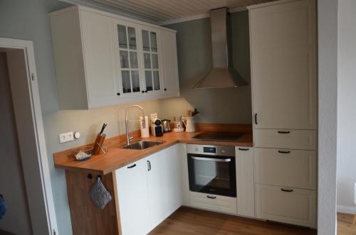 圣安德里斯伯格Harz-Butze的厨房配有白色橱柜和水槽