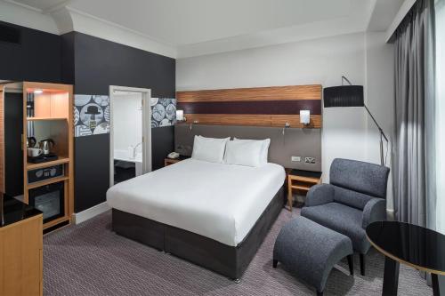 诺丁汉假日皇冠诺丁汉酒店的一间卧室配有一张床、一张桌子和一把椅子