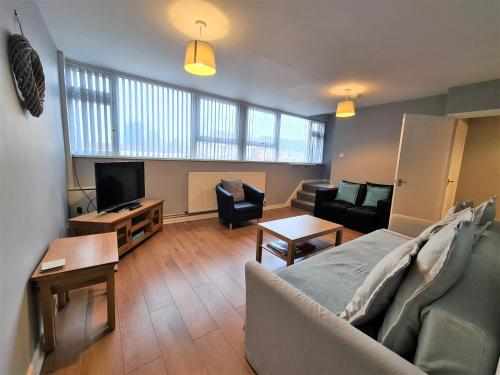 考文垂3 Bedroom Apartment Coventry - Hosted by Coventry Accommodation的带沙发和电视的客厅
