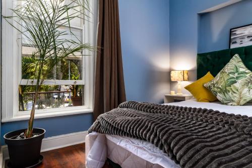 开普敦Obz Hotel的一间卧室设有一张大床和一个窗户。