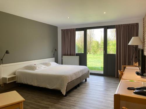 洛布奥特桑布尔酒店的一间卧室设有一张床和一个大窗户