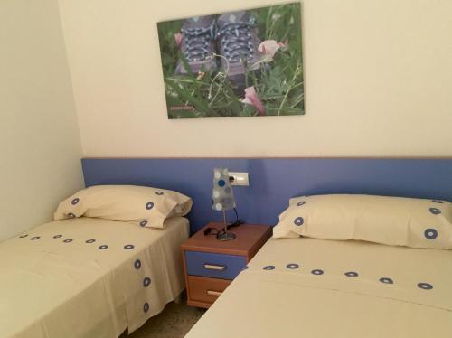 安波拉Pinets的卧室配有两张床,墙上挂着一幅画