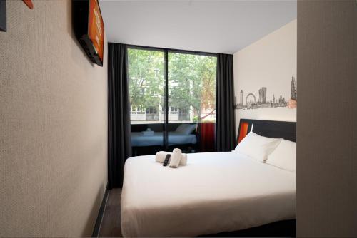 牛津easyHotel Oxford的酒店客房设有白色的床和窗户。