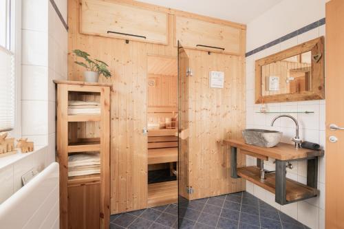 隆高地区圣玛格丽滕Pistenblick Chalet的带淋浴的浴室和木墙