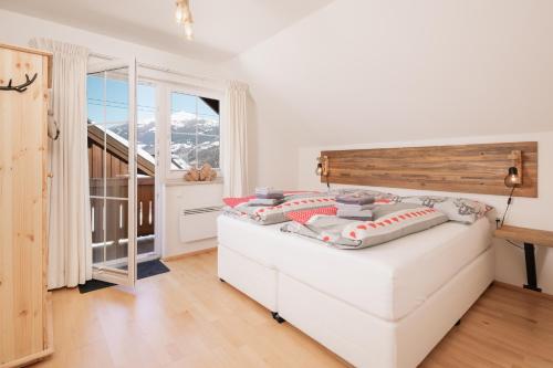 隆高地区圣玛格丽滕Pistenblick Chalet的一间卧室设有一张床和一个大窗户