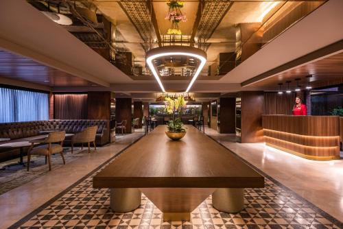 波哥大埃斯特拉拉丰塔纳酒店的一间位于客房中间的带大木桌的餐厅
