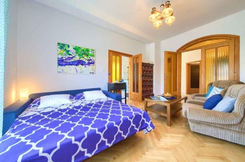 瓦比尼科Apartment in Vrbnik/Insel Krk 35995的卧室配有蓝色和白色的床和沙发