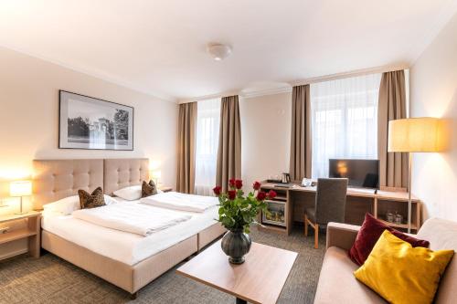 萨尔茨堡Altstadthotel Wolf-Dietrich的配有一张床和一张书桌的酒店客房