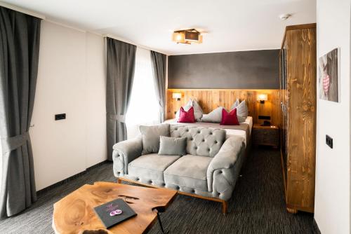 瓦德林Waidringer Hof 4 Sterne Superior的酒店客房设有一张沙发和一张床