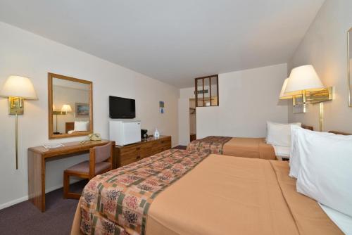 北普拉特美洲最佳价值旅馆北普拉特的酒店客房设有两张床、一张桌子和一面镜子
