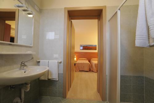 圣米凯莱亚尔塔利亚门托Terzo Bacino的一间带水槽和淋浴的浴室以及一间卧室