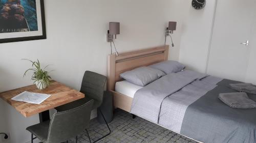 WerkendamBiesbosch Bed & Breakfast Werkendam的小房间设有一张床、一张桌子和一张书桌