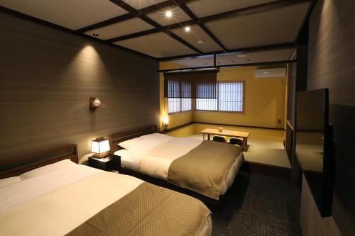 金泽Hanaakari的酒店客房设有两张床和电视。