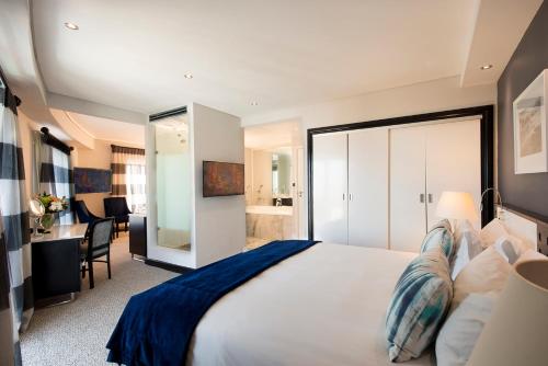 开普敦科莫多酒店的卧室配有一张白色大床和一张书桌