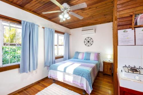 桑迪湾Guava Grove Resort & Villas的一间卧室配有一张床和吊扇