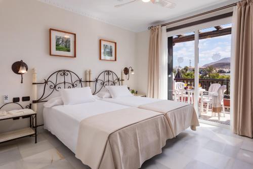 美洲海滩Parque Santiago V Official的一间白色卧室,配有两张床和一个阳台