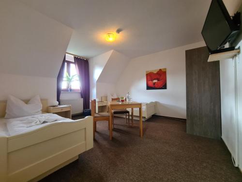 文斯托夫希铁诺酒店的一间卧室配有一张床、一张桌子和一台电视