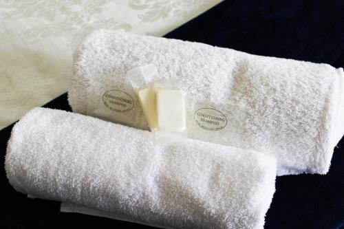 乌平通Marikal Guesthouse的2条毛巾和1瓶桌上肥皂