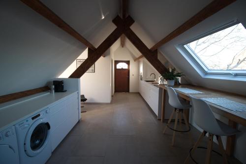 KampenhoutDe Heide, cozy apartment with separate entrance的阁楼设有带洗衣机和烘干机的洗衣房
