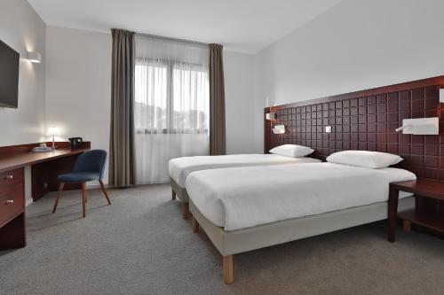 Saint-Laurent-sur-ManoireKYRIAD Périgueux - Boulazac的酒店客房配有两张床和一张书桌