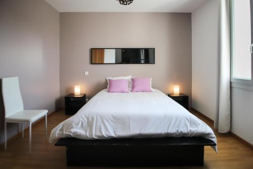埃瑞兹Maison tendance avec jardin, centre village, Alpilles, familles的卧室配有一张大床和两个粉红色枕头