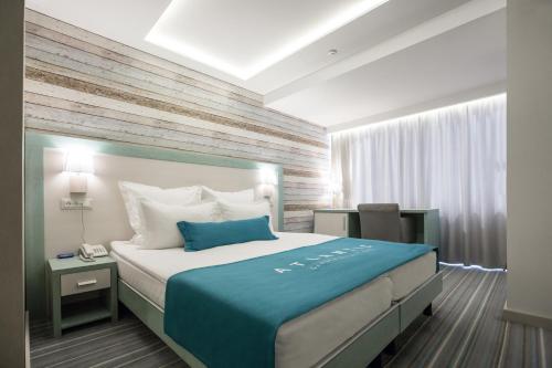 敖德萨大西洋花园度假酒店的一间卧室配有一张带蓝色毯子的大床